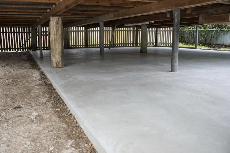 Finished concrete slab under a raised timber cottage, formwork stripped, illustrative example