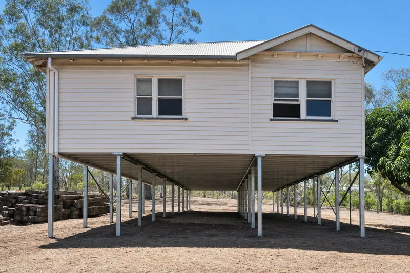 Timber Queenslander cottage raised on steel posts with full underfloor void exposed, illustrative example