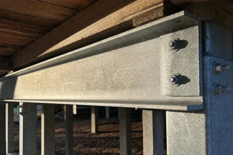 Galvanised steel PFC beam bolted under floor joists of a raised house, illustrative example