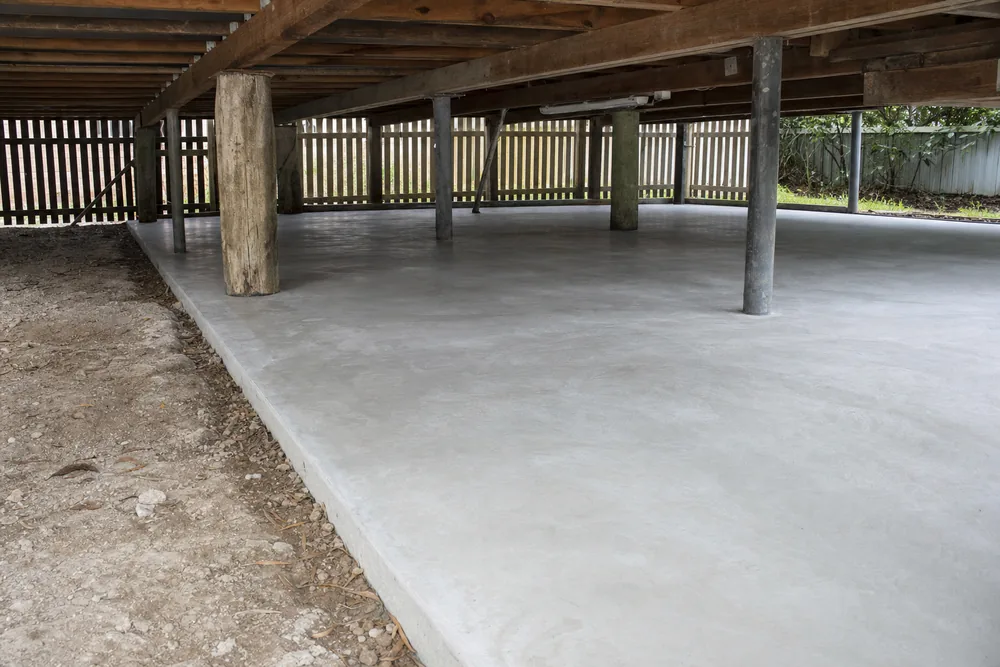 Finished concrete slab under a raised timber cottage, formwork stripped, illustrative example