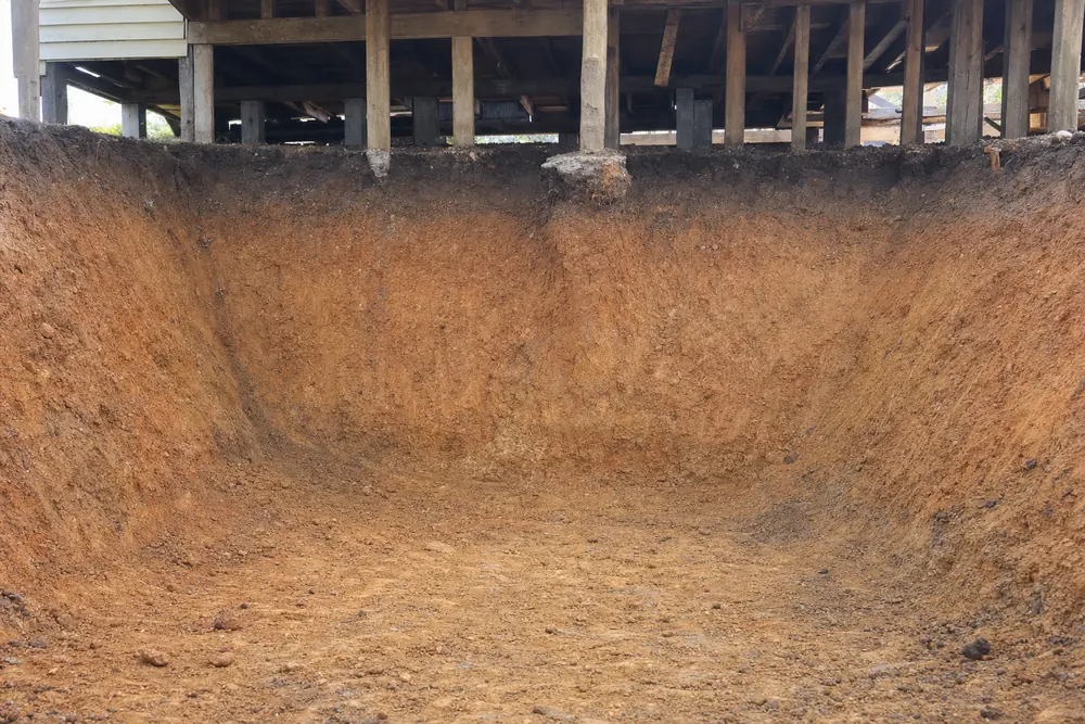 Excavated clay cut face under a raised house showing the soil profile, illustrative example